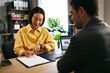 © djile - Businesswoman signing contract during meeting with client