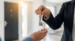 © Life Art - close-up photo of a real estate agent holding home keychain in her hand and showing to new owner.property ownership and high-value investment.