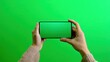 © darshika - Hands Holding Smartphone with Green Screen