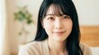© AiPhoto - 20代女性が室内でリラックスして穏やかな表情で見つめるアップ