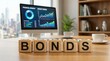 © Pinit - A professional office setting featuring wooden blocks with the word BONDS and financial data on a monitor.