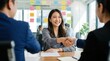 © Pinit - Two employers shaking hands with a smiling Asian woman after a successful business negotiation.
