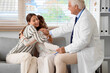 © Pixel-Shot - Young lesbian couple with fertility doctor hugging after IVF in clinic