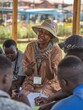 © Johannes - Kenyan woman leading youth climate workshop in outdoor community space, engaging with passion on a sunny afternoon