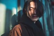 © pham - ガラスの壁の近くに立っている長い髪の若い男性