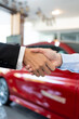 © BJ Day Stock - Close-up of a professional handshake in a car dealership. Successful vehicle purchase deal between dealer and client. Automotive sales and service concept. Vertical Shot