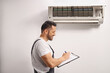 © Ljupco Smokovski - Air conditioner technician inspecting an indoor unit