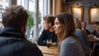 © Bussakon - Two friends engaged in lively conversation while sitting at a wooden table in a stylish warm cafe setting