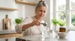 © Maryia - Mature woman preparing daily creatine drink shows healthy aging wellness routine, simple strength support and modern supplement habit in clean kitchen. Protein shake