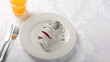 © Edson Souza - Measuring tape on a plate with orange juice for diet concept.