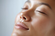 © Marut - Close up portrait of relaxed face with closed eyes showing smooth skin, natural makeup, soft shadow and serene expression, perfect for skincare or wellness concept