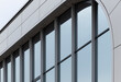 © valiantsin - Modern office building facade with glass windows and curved architectural detail. Clean exterior lines create a contemporary commercial property look.