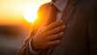 © Robi - A man in a suit places his hand over his heart against a sunset