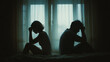 © Lemonkey - Silhouettes of a couple sitting apart in emotional distress inside a dark room, symbolizing relationship problems, separation, loneliness, and mental struggle.