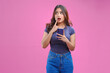© ChristyMerry - Thoughtful young Asian woman wearing blue shirt while holding smartphone.