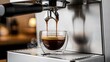 © ANIK - Espresso pouring from professional coffee machine into glass cup with rich crema and steam