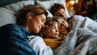 © Julia - Family of four sleeping across a large bed under tousled blankets on a lazy holiday morning seen from overhead cozy relaxed mood