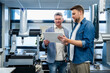 © Westend61 - Engineers discussing project on tablet in production hall