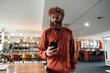 © Westend61 - Mature businessman using smart phone near table in office cafeteria
