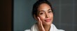 © ckybe - Joyful biracial young woman pampering her skin like a garden in a sleek bathroom
