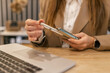 © руслан малыш - Close up of woman holding electronic cigarette device near laptop in cafe, modern lifestyle and vaping alternative concept