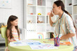 © Pixel-Shot - Female Asian speech therapist working with little girl in office