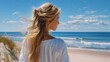 © Iaroslav - Young woman enjoying summer beach vacation, blonde hair blowing in wind, watching ocean waves