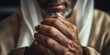 © NovaVision - Close-up of an elderly man's hands clasped in prayer, showing deep wrinkles and weathered skin
