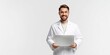 © NovaVision - Young male doctor in white lab coat holding a laptop and smiling confidently