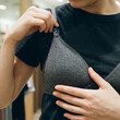 © Cliff - Close-up of a young woman trying on a bra in a fitting room of a lingerie store, concept of shopping, lingerie selection, body positivity and women's fashion