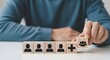 © GOKULRATAN - Human resources concept wooden blocks with people icons representing team building and recruitment