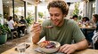 © creativestock - A young man eating a healthy meal at a restaurant with a bowl of fruit and granola
