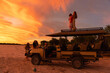 © Marc Romanelli - Family on vacation experiencing sunset over the Nxai Pan, Kalahari Desert, Botswana, Africa
