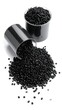 © Men - Monochrome shot of plastic granules spilling from a cup, another cup in background. The granules are spread out