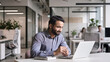 © insta_photos - Smiling bearded indian businessman working on laptop at home office. Young indian student using computer remote studying, virtual training on video call meeting, watching online webinar or seminar.