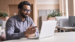 © insta_photos - Happy indian business man remote teacher, customer support manager wearing headset talking at virtual meeting consulting client on video call giving distance learning class at home office call center.