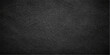 © Alpha Designs - A dark textured black leather surface with a rough macro pattern and grunge textile structure creates a blank material backdrop for a professional design wallpaper