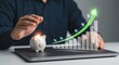 © MumarProject - Piggy bank and growing financial graph with upward arrow on laptop, business growth concept