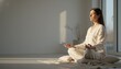 © aukkasit - Woman practicing meditation in a bright minimalist home interior