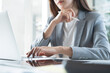 © tippapatt - Businesswoman focus working at office using laptop with digital tablet on desk, corporate business concept