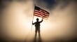 © MdAhsanul - Silhouette of brave american soldier holding flag against golden sunrise in hazy environment.