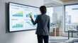 © Sophia - Business woman presenting global renewable portfolio update on large wall display screen with bar charts and graphs in modern glass office with city view.