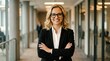 © PhamKhac - Confident Businesswoman with Glasses Standing in Office Hallway