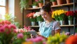 © miss irine - Young woman florist checks orders on tablet in colorful shop. Female entrepreneur manages online sales surrounded by fresh plants and vibrant floral bouquets, happy at work.