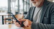 © Tan - Elderly man with white beard using a smartphone with his finger, representing digital nomad lifestyle.