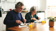 © Ladanifer - Senior couple eating pancakes and fruit, sharing a morning meal at home