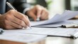 © FANTASY WORLD - Close up of a businessman in a suit signing a contract or document with a pen reviewing important paperwork on a desk with shallow depth of field professional legal agreement