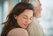 © cjsolanop - Soft sunlight glows behind two embracing figures. Woman rests her head on man's shoulder, eyes closed. Her smile reveals quiet contentment, peaceful trust. Man holds her close, offering steady