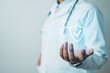 © Garun Studios - Health insurance concept with doctor holding digital protection shield, representing medical coverage, patient care, and healthcare security, emphasizing benefits, policy protection.