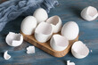 © Pixel-Shot - Holder with egg shells on blue wooden table